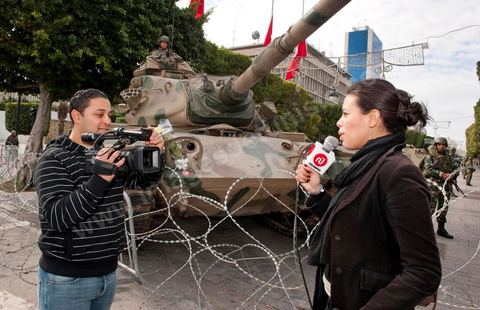 Journaliste de la télévision satellitaire privé tunisienne couvrant une manifestation de l'UGTT et interviewant les militaires sur l'avenue Habib Bourguiba à Tunis. Les journalistes tunisiens découvrent une liberté de la presse et investissent le terrain.