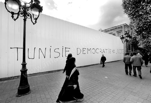 Sur les murs de la ville les slogans et les pancartes des manifestants de la Révolution du Peuple s'affichent en arabe et en français.