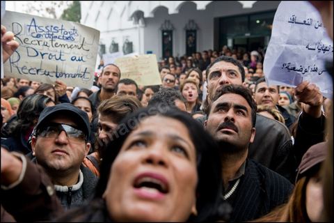 Les chercheurs et les professeurs d'universit sont  l'coute le discours du ministre de l'ducation et la recherche scientifique Ahmed Brahim au ministre le 25 Janvier 2011. Les manifestants affirment qu'ils continueront leur sit-in jusqu' la chute du gouvernement intrimaire et la satisfaction de leurs revendications pour une vie dcente.