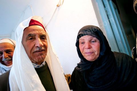 9 février : Les hommes venus prier et rendre hommage à Mohamed viennent saluer et soutenir la maman de Mohamed avant de se retirer. A la maison de Mohamed Bouazizi le 40ème jour de sa mort. Avec sa famille proche, mère, oncle, frère et soeurs, et amis du quartier célébration du 40ème jour de la mort de Mohamed Bouazizi. Dans la culture musulmane, le 40ème jour est le jour ou l'âme du défunt quitte la terre pour rejoindre le paradis, mùais aussi le jour où les parents doivent accepter ce départ de l'etre cher, le jour où l'on décrète la fin du deuil. ce jour là les proches de la famille viennent manger à la maison de la famille du défunt.