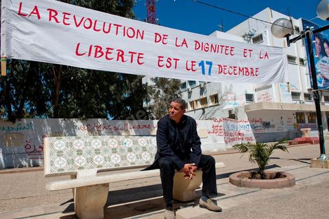 Un des membres du comité de protection de la révolution du 17 décembre 2010 devant une banderolle à Sidi bouzid. Révolution du 17 décembre 2010 et non du 14 janvier 2011.
