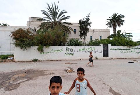 Jeunes dans une rue aux murs taggués à Hammam Lif