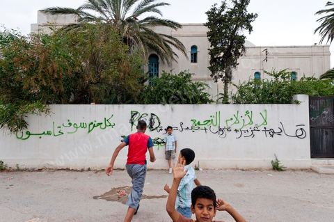 Jeunes dans une rue aux murs taggués à Hammam Lif