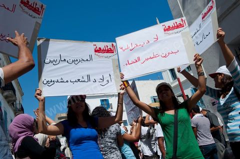 10 août 2011 : Quelque trois cents personnes ont de nouveau manifesté ce matin dans le centre de Tunis pour "une justice indépendance" et une rupture avec l'ancien régime de Ben Ali: "Le peuple veut une justice indépendante", "Ni liberté, ni impunité pour les criminels", ont scandé les manifestants tapant dans leurs mains sur les marches du Théâtre, au coeur de la capitale tunisienne.  Certains manifestaient sous la bannière de partis politiques, d'autres en tant qu'indépendants ou syndicalistes se tenaient en retrait sur le terre-plein de l'Avenue centrale Habib Bourguiba, contenus par de nombreux effectifs de la police. "Nous sommes d'accord sur les revendications: justice indépendante, non à l'impunité, information libre et purge des résidus de l'ancien régime", a déclaré un enseignant syndicaliste dans le camp des indépendants : "Nous voulons couper les ponts avec le régime de Ben Ali", affirmant que les protestations se poursuivront jusqu'au départ des symboles du système déchu encore en place". Sur des panneaux, les manifestants ont dénoncé la fuite d'une figure emblématique de la propagande sous Ben Ali, Saida Agrebi, qui était sous le coup d'une plainte en justice, et le retour sur la scène de certains membres du Rassemblement constitutionnel démocratique, parti de Ben Ali dissous après la chute de son régime le 14 janvier. "Nous avons le devoir de ne pas laisser confisquer la révolution, d'être fidèle aux martyrs", a scandé un responsable politique.