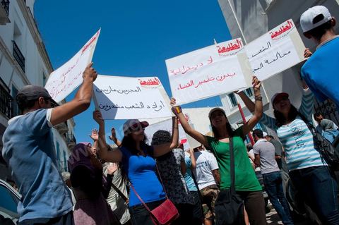 10 août 2011 : Quelque trois cents personnes ont de nouveau manifesté ce matin dans le centre de Tunis pour "une justice indépendance" et une rupture avec l'ancien régime de Ben Ali: "Le peuple veut une justice indépendante", "Ni liberté, ni impunité pour les criminels", ont scandé les manifestants tapant dans leurs mains sur les marches du Théâtre, au coeur de la capitale tunisienne.  Certains manifestaient sous la bannière de partis politiques, d'autres en tant qu'indépendants ou syndicalistes se tenaient en retrait sur le terre-plein de l'Avenue centrale Habib Bourguiba, contenus par de nombreux effectifs de la police. "Nous sommes d'accord sur les revendications: justice indépendante, non à l'impunité, information libre et purge des résidus de l'ancien régime", a déclaré un enseignant syndicaliste dans le camp des indépendants : "Nous voulons couper les ponts avec le régime de Ben Ali", affirmant que les protestations se poursuivront jusqu'au départ des symboles du système déchu encore en place". Sur des panneaux, les manifestants ont dénoncé la fuite d'une figure emblématique de la propagande sous Ben Ali, Saida Agrebi, qui était sous le coup d'une plainte en justice, et le retour sur la scène de certains membres du Rassemblement constitutionnel démocratique, parti de Ben Ali dissous après la chute de son régime le 14 janvier. "Nous avons le devoir de ne pas laisser confisquer la révolution, d'être fidèle aux martyrs", a scandé un responsable politique.