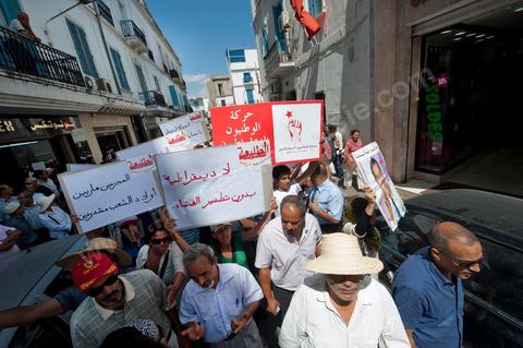 10 août 2011 : Quelque trois cents personnes ont de nouveau manifesté ce matin dans le centre de Tunis pour "une justice indépendance" et une rupture avec l'ancien régime de Ben Ali: "Le peuple veut une justice indépendante", "Ni liberté, ni impunité pour les criminels", ont scandé les manifestants tapant dans leurs mains sur les marches du Théâtre, au coeur de la capitale tunisienne.  Certains manifestaient sous la bannière de partis politiques, d'autres en tant qu'indépendants ou syndicalistes se tenaient en retrait sur le terre-plein de l'Avenue centrale Habib Bourguiba, contenus par de nombreux effectifs de la police. "Nous sommes d'accord sur les revendications: justice indépendante, non à l'impunité, information libre et purge des résidus de l'ancien régime", a déclaré un enseignant syndicaliste dans le camp des indépendants : "Nous voulons couper les ponts avec le régime de Ben Ali", affirmant que les protestations se poursuivront jusqu'au départ des symboles du système déchu encore en place". Sur des panneaux, les manifestants ont dénoncé la fuite d'une figure emblématique de la propagande sous Ben Ali, Saida Agrebi, qui était sous le coup d'une plainte en justice, et le retour sur la scène de certains membres du Rassemblement constitutionnel démocratique, parti de Ben Ali dissous après la chute de son régime le 14 janvier. "Nous avons le devoir de ne pas laisser confisquer la révolution, d'être fidèle aux martyrs", a scandé un responsable politique.