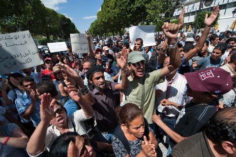 10 août 2011 : Quelque trois cents personnes ont de nouveau manifesté ce matin dans le centre de Tunis pour "une justice indépendance" et une rupture avec l'ancien régime de Ben Ali: "Le peuple veut une justice indépendante", "Ni liberté, ni impunité pour les criminels", ont scandé les manifestants tapant dans leurs mains sur les marches du Théâtre, au coeur de la capitale tunisienne.  Certains manifestaient sous la bannière de partis politiques, d'autres en tant qu'indépendants ou syndicalistes se tenaient en retrait sur le terre-plein de l'Avenue centrale Habib Bourguiba, contenus par de nombreux effectifs de la police. "Nous sommes d'accord sur les revendications: justice indépendante, non à l'impunité, information libre et purge des résidus de l'ancien régime", a déclaré un enseignant syndicaliste dans le camp des indépendants : "Nous voulons couper les ponts avec le régime de Ben Ali", affirmant que les protestations se poursuivront jusqu'au départ des symboles du système déchu encore en place". Sur des panneaux, les manifestants ont dénoncé la fuite d'une figure emblématique de la propagande sous Ben Ali, Saida Agrebi, qui était sous le coup d'une plainte en justice, et le retour sur la scène de certains membres du Rassemblement constitutionnel démocratique, parti de Ben Ali dissous après la chute de son régime le 14 janvier. "Nous avons le devoir de ne pas laisser confisquer la révolution, d'être fidèle aux martyrs", a scandé un responsable politique.