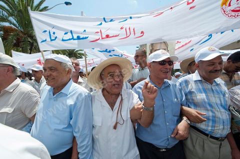 15 août 2011 : Abdessalem JRAD, Secrétaire Général de l'UGGT et Ahmed BRAHIM, secrétaire général du Parti démocrate Ettajdid à la maNif de l'UGGT. L'Union Générale Tunisienne du Travail a organisé une marche de protestation ''pour la réalisation des objectifs de la révolution et en mémoire des martyrs'' qui a débuté lundi 15 août 2011 à midi devant la bourse du travail à Tunis avant de parcourir l'avenue Mohamed V et de se disperser devant la place des droits de l'Homme.Ont participé à cette marche, les structures régionales et locales de base de l'Union, des partis politiques, des personnalités nationales, des composantes de la société civile, des intellectuels et des artistes.Les manifestants ont exprimé des revendications à caractère social et politique exigeant notamment le départ du Gouvernement de transition et de demander des comptes aux symboles de la corruption, notamment par une restitution des avoirs du peuple, spoliés par la famille du président déchu, la réforme de la Justice et l'emploi aux chômeurs.Les manifestants ont dénoncé la hausse des prix et appelé au respect des principes de la révolution et à la fidélité au sang des martyrs.La marche a été marquée par un arrêt symbolique devant le siège de l'ancien Rassemblement Constitutionnel Démocratique dissous."La Tunisie libre et les voleurs dehors", "Peuple, révolte-toi contre les restants de la dictature", "Pas de liberté, pas de retour, pour les bandes du destour" ont scandé les manifestants.
