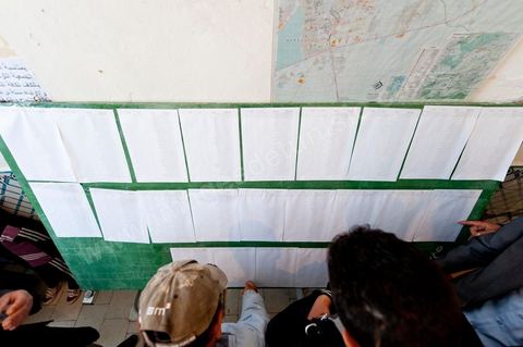 Le jour du scrutin les électeurs inscrits recherchent leur nom et leur bureau de vote sur les listes dans un bureau de vote au centre ville du Kef