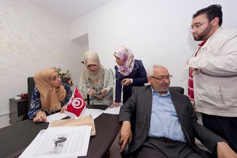 Dans le bureau Rached Ghannouchi, président et fondateur de Ennahdha, notent avec ses filles Soumaya (à gauche), Intissar (au centre), Yosr (à droite) et Bara (à droite) le fils notent les  résultats provisoires lors de la soirée de résultats au QG du parti Ennahda à Tunis. 