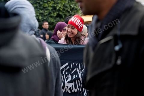 14 janvier 2012 : Une jeune fille pose avec le drapeau du parti salafiste Hizbut Tharir sur l'aveneu Habib Bourguiba lors de la Commémoration à Tunis du premier anniversaire de la Révolution tunisienne, le 14 janvier étant la date de la fuite de l'ex Président vers l'Arabie Saoudide. 