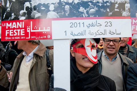 14 janvier 2012 : Deux jeunes femmes promènent sur l'avenue une expo de photos de la Révolution tunisienne au nom du Manifeste du 20 mars 2011. Commémoration à Tunis du premier anniversaire de la Révolution tunisienne, le 14 janvier étant la date de la fuite de l'ex Président vers l'Arabie Saoudide. 