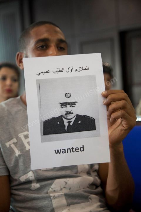 Le frère d'une des victimes de la répression de janvier 2011 montre la photo du policier présumé coupable de la mort de son frère.