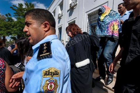 2 octobre 2012 : Sortie des jeunes fiancés de Tunis, la femme violée sous un voile noir et dans les brasp de son avocate et le fiancé sous une serviette pour préserver l'anonymat de ce jeune couple victime de la police après leur passage chez le juge ce matin. La femme violée par des policiers et son fiancé ont été interrogée ce matin par un juge d'instruction de Tunis qui doit décider de l'inculper ou non d'"atteinte à la pudeur". A l'issue d'un interrogatoire de plus de deux heures mené par Mohamed Ben Meftah, les avocats de la victime se sont dits "optimistes" quant à l'abandon des poursuites contre leur cliente et son fiancé pour ce délit passible de six mois de prison. Le juge d'instruction doit décider dans les heures ou les jours à venir de "classer l'affaire ou la transférer devant le tribunal compétent".