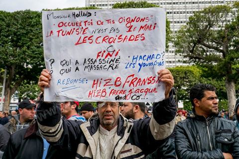 14 janvier 2013 : Militant d'Ennahdha parti islmaiste au pouvoir en Tunisie brandissant des banderolles de protestation contre l'intervention d ela France au Mali. Entre l'avenue Habib Bourguiba et la place du 14 janvier, les tunisiens sont venus commémorer, dans une ambiance politique tendue, le deuxième anniversaire d ela Révolution marqué en 2011 par la fuite de l'ancien président Ben Ali.