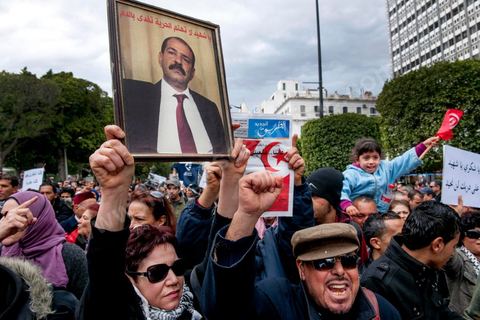 23 février 2013 : la foule brandit le portrait de Chokri Bealid. près de 3000 partisans et citoyens sont venus protester devant le Ministère de l'Intérieur pour la lenteur de l'enquête sur l'assassinat du militant politique Chokri Belaid le 6 février dernier. Les slogans ont aussi accusé le parti au pouvoir Ennahdha et son dirigeant Rached Ghannouchi.