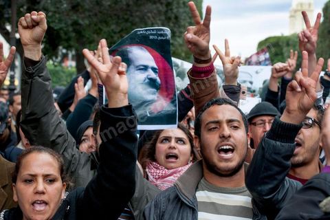 23 février 2013 : la foule brandit le portrait de Chokri Bealid. près de 3000 partisans et citoyens sont venus protester devant le Ministère de l'Intérieur pour la lenteur de l'enquête sur l'assassinat du militant politique Chokri Belaid le 6 février dernier. Les slogans ont aussi accusé le parti au pouvoir Ennahdha et son dirigeant Rached Ghannouchi.