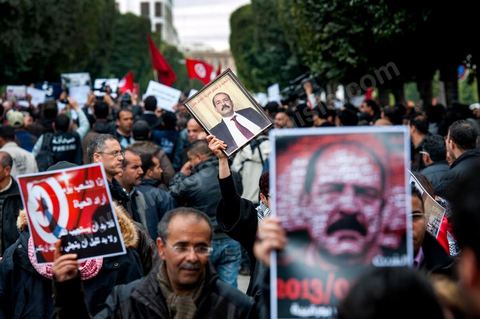 23 février 2013 : la foule brandit le portrait de Chokri Bealid. près de 3000 partisans et citoyens sont venus protester devant le Ministère de l'Intérieur pour la lenteur de l'enquête sur l'assassinat du militant politique Chokri Belaid le 6 février dernier. Les slogans ont aussi accusé le parti au pouvoir Ennahdha et son dirigeant Rached Ghannouchi.