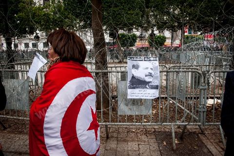 23 février 2013 : la foule brandit le portrait de Chokri Bealid. près de 3000 partisans et citoyens sont venus protester devant le Ministère de l'Intérieur pour la lenteur de l'enquête sur l'assassinat du militant politique Chokri Belaid le 6 février dernier. Les slogans ont aussi accusé le parti au pouvoir Ennahdha et son dirigeant Rached Ghannouchi.