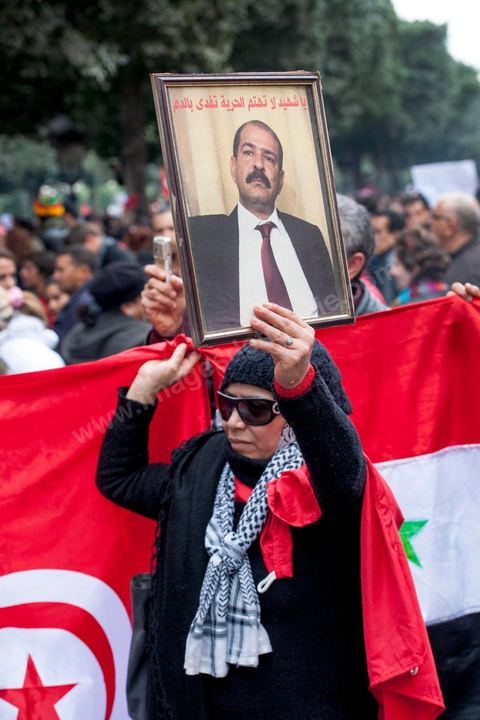 23 février 2013 : la foule brandit le portrait de Chokri Bealid. près de 3000 partisans et citoyens sont venus protester devant le Ministère de l'Intérieur pour la lenteur de l'enquête sur l'assassinat du militant politique Chokri Belaid le 6 février dernier. Les slogans ont aussi accusé le parti au pouvoir Ennahdha et son dirigeant Rached Ghannouchi.