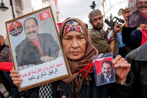 09 mars 2013 : Femme avec portrait de Chokri Belaid sur l'avenue Habib Bourguiba à Tunis, près de 3000 manifestants pour commémorer la femme de la Femme et le décès de Chokri Belaid le 6 février. Plusieurs personnalités politiques, des activistes de la société civile et des artistes  ont répondu présent à l'appel de la commission Femmes de l'UGTT ainsi que d'autres organisations féministes.