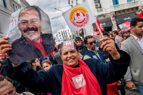09 mars 2013 : Femme avec portrait de Chokri Belaid sur l'avenue Habib Bourguiba à Tunis, près de 3000 manifestants pour commémorer la femme de la Femme et le décès de Chokri Belaid le 6 février. Plusieurs personnalités politiques, des activistes de la société civile et des artistes  ont répondu présent à l'appel de la commission Femmes de l'UGTT ainsi que d'autres organisations féministes.