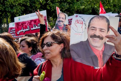 09 mars 2013 : Femme avec portrait de Chokri Belaid sur l'avenue Habib Bourguiba à Tunis, près de 3000 manifestants pour commémorer la femme de la Femme et le décès de Chokri Belaid le 6 février. Plusieurs personnalités politiques, des activistes de la société civile et des artistes  ont répondu présent à l'appel de la commission Femmes de l'UGTT ainsi que d'autres organisations féministes.