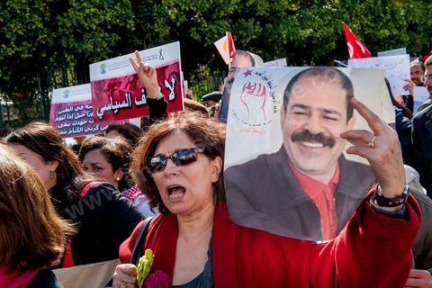 09 mars 2013 : Femme avec portrait de Chokri Belaid sur l'avenue Habib Bourguiba à Tunis, près de 3000 manifestants pour commémorer la femme de la Femme et le décès de Chokri Belaid le 6 février. Plusieurs personnalités politiques, des activistes de la société civile et des artistes  ont répondu présent à l'appel de la commission Femmes de l'UGTT ainsi que d'autres organisations féministes.