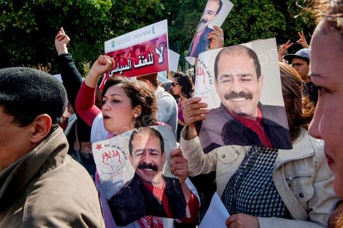 09 mars 2013 : Femme avec portrait de Chokri Belaid sur l'avenue Habib Bourguiba à Tunis, près de 3000 manifestants pour commémorer la femme de la Femme et le décès de Chokri Belaid le 6 février. Plusieurs personnalités politiques, des activistes de la société civile et des artistes  ont répondu présent à l'appel de la commission Femmes de l'UGTT ainsi que d'autres organisations féministes.