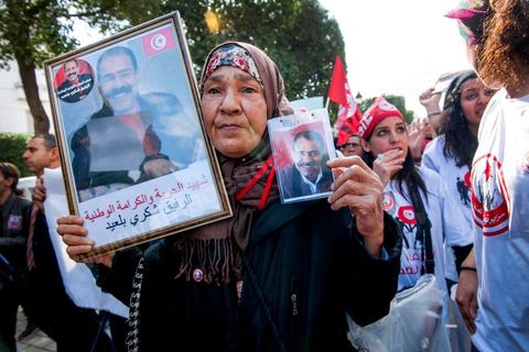 09 mars 2013 : Femme avec portrait de Chokri Belaid sur l'avenue Habib Bourguiba à Tunis, près de 3000 manifestants pour commémorer la femme de la Femme et le décès de Chokri Belaid le 6 février. Plusieurs personnalités politiques, des activistes de la société civile et des artistes  ont répondu présent à l'appel de la commission Femmes de l'UGTT ainsi que d'autres organisations féministes.