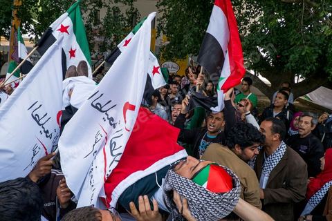 29 mars 2013 : face à face très tendu et légers affrontements entre des syriens pro rebellion (drapeau trois étoiles rouges) et militants tunisiens du parti Bass pro Bachar El Assad avec au milieu des manifestants pro palestiniens brandissant un faux cadavre sur la place centrale du FSM au dernier jour des rencontres du Forum Social Mondial sur le campus universitaire de Tunis. Ce premier forum en Terre arabe a été fortement marqué par les revendicatiosn et constatestations nationaliste arabes, et dominé par un hommage et soutien constant au peuple palestinien.