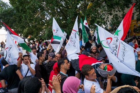 29 mars 2013 : face à face très tendu et légers affrontements entre des syriens pro rebellion (drapeau trois étoiles rouges) et militants tunisiens du parti Bass pro Bachar El Assad avec au milieu des manifestants pro palestiniens brandissant un faux cadavre sur la place centrale du FSM au dernier jour des rencontres du Forum Social Mondial sur le campus universitaire de Tunis. Ce premier forum en Terre arabe a été fortement marqué par les revendicatiosn et constatestations nationaliste arabes, et dominé par un hommage et soutien constant au peuple palestinien.