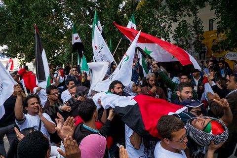 29 mars 2013 : face à face très tendu et légers affrontements entre des syriens pro rebellion (drapeau trois étoiles rouges) et militants tunisiens du parti Bass pro Bachar El Assad avec au milieu des manifestants pro palestiniens brandissant un faux cadavre sur la place centrale du FSM au dernier jour des rencontres du Forum Social Mondial sur le campus universitaire de Tunis. Ce premier forum en Terre arabe a été fortement marqué par les revendicatiosn et constatestations nationaliste arabes, et dominé par un hommage et soutien constant au peuple palestinien.