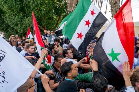 29 mars 2013 : face à face très tendu et légers affrontements entre des syriens pro rebellion (drapeau trois étoiles rouges) et militants tunisiens du parti Bass pro Bachar El Assad sur la place centrale du FSM au dernier jour des rencontres du Forum Social Mondial sur le campus universitaire de Tunis. Ce premier forum en Terre arabe a été fortement marqué par les revendicatiosn et constatestations nationaliste arabes, et dominé par un hommage et soutien constant au peuple palestinien.