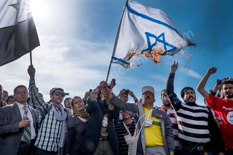 29 mars 2013 : les militants tunisiens du parti Bass pro Bachar El Assad sur la place centrale du FSM brule le drapeau israélien au dernier jour des rencontres du Forum Social Mondial sur le campus universitaire de Tunis. Ce premier forum en Terre arabe a été fortement marqué par les revendicatiosn et constatestations nationaliste arabes, et dominé par un hommage et soutien constant au peuple palestinien.