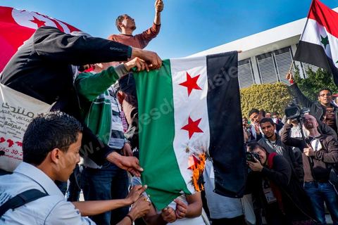 29 mars 2013 : les militants tunisiens du parti Bass pro Bachar El Assad sur la place centrale du FSM brule le drapeau des rebelles syriens au dernier jour des rencontres du Forum Social Mondial sur le campus universitaire de Tunis. Ce premier forum en Terre arabe a été fortement marqué par les revendicatiosn et constatestations nationaliste arabes, et dominé par un hommage et soutien constant au peuple palestinien.