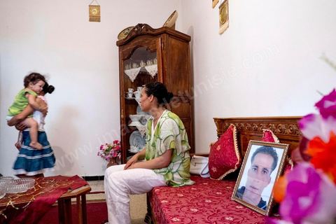 Dans le salon avec ses deux filles et le portrait de son mari disparu. Chez Omelkhir ouiretani, cette jeune femme mère de 2 filles recherche son mari Nabil disparu sur le bateau du 29 mars 2011, dans le quartier de Kabaria.