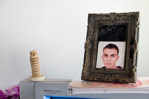 A Kabaria, quartier populaire de la banlieue sud de Tunis, Chez Nourredine MBAREK, père de Karim disparu le 29 mars 2011. Portrait de Karim posé sur la Télé du salon à côté d'une tour de Pise.