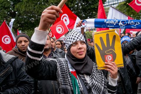 14 janvier 2014 : Militants d'Ennahdha, sur l'avenue Habib Bourguiba à Tunis quelques milliers de tunisiens sont venus se rassembler pour commémorer le troisième anniversaire du départ de l'ancien Président Ben Ali, aboutissement des mouvements de révoltes en région démarrés le 17 décmbre 2010. Tous les genres politiques se croisent et se chamaillent l'avenue, d'un côté les islamistes avec Ennahdha, les ligues et même un nouveau mouvement islamiste anachiste, de l'autre la gauche et l'opposition commémorant à la fois le départ des anciens et la mémoire des martyrs de la révolution et des martyrs politiques. 