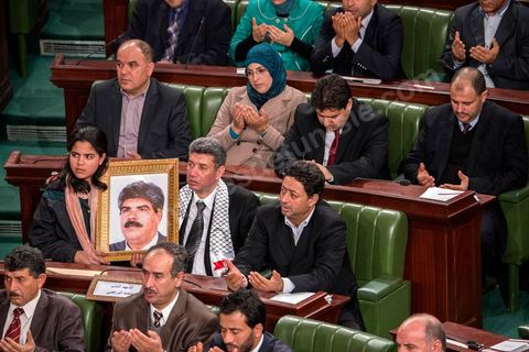 27 janvier 2014 : Prière lors de la cérémonie de signature de la Constitution à l'assemblée constituante, le 27 janvier 2014 en présence de personnalités nationales et internationales. Au premier plan, la fille du député assassiné le 25 juillet 2013, Mohamed Brahmi, tient un portrait de son père, avec le député Mourad Amdouni.