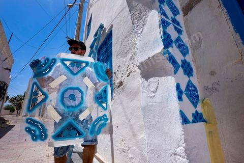 Oeuvre de l'artiste portugais ADD FUEL pour le Projet DjerbaHood : après la Tour Paris 13, la team Itinerrance dépose ses valises dans un village traditionnel de l’île de Djerba, Erriadh. Depuis le début du mois de juillet, le village d’Erriadh se métamorphose petit à petit pour devenir un véritable musée à ciel ouvert. Une sélection d’artistes des quatre coins du monde ont été invités à s’exprimer dans ce décor unique à l’architecture authentique : murs blancs, portes bleues turquoises, dômes, veilles constructions et divers lieux abandonnés, autant de possibilités qui donneront naissance à des créations uniques aux couleurs locales.