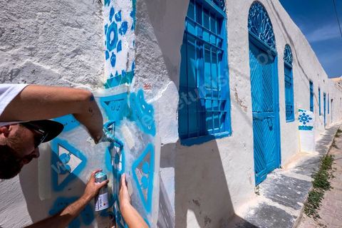 Oeuvre de l'artiste portugais ADD FUEL pour le Projet DjerbaHood : après la Tour Paris 13, la team Itinerrance dépose ses valises dans un village traditionnel de l’île de Djerba, Erriadh. Depuis le début du mois de juillet, le village d’Erriadh se métamorphose petit à petit pour devenir un véritable musée à ciel ouvert. Une sélection d’artistes des quatre coins du monde ont été invités à s’exprimer dans ce décor unique à l’architecture authentique : murs blancs, portes bleues turquoises, dômes, veilles constructions et divers lieux abandonnés, autant de possibilités qui donneront naissance à des créations uniques aux couleurs locales.