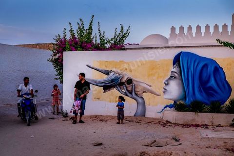 Oeuvre de l'artiste française LILIWEEN pour le Projet DjerbaHood : après la Tour Paris 13, la team Itinerrance dépose ses valises dans un village traditionnel de l’île de Djerba, Erriadh. Depuis le début du mois de juillet, le village d’Erriadh se métamorphose petit à petit pour devenir un véritable musée à ciel ouvert. Une sélection d’artistes des quatre coins du monde ont été invités à s’exprimer dans ce décor unique à l’architecture authentique : murs blancs, portes bleues turquoises, dômes, veilles constructions et divers lieux abandonnés, autant de possibilités qui donneront naissance à des créations uniques aux couleurs locales.