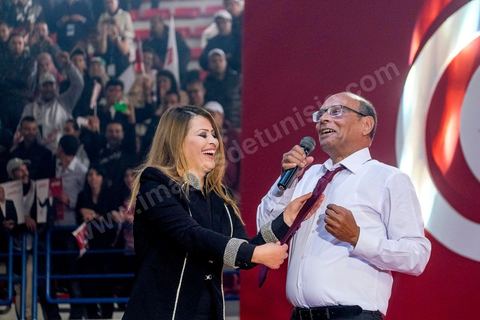 14 décembre 2014 : Au milieu de son speech, deux jeunes femmes sont arrivées sur le podium en ramenant un cadeau au candidat au second tour de l’élection présidentielle une cravate rouge ! Connu pour avoir toujours refusé de porter de cravate, afin de ne pas rompre son élan populiste, Moncef Marzouki a accepté le cadeau des deux jeunes filles et l’a même porté sur le champ. Grand meeting de Moncef Marzouki qui fait salle comble à la coupole de Tunis à une semaine du 2d tour des élections présidentielles. Moncef Marzouki, a appelé ses partisans, « à ne pas tomber dans le piège des insultes et à ne pas dire du mal de son rival Béji Caid Essebsi », tout en affirmant «nous avons le droit de juger cet homme pour son passé et pour son rôle destructeur au cours de la phase transitoire…, mais notre combat est celui des valeurs et l’éthique».Le président sortant et candidat au second tour de la présidentielle a tenu dimanche un meeting au palais des sports d’El Menzah. Ses partisans venus des différentes régions du pays ont scandé des slogans hostiles à son rival Béji Caid Essebsi et à son parti Nidaa Tounes.