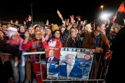 21 décembre 2014 : Militant avec portrait historique de Habib Bourguiba et de Béji Caid Essebsi. Dès la fin du scrutin à 18h, les rumeurs d'une large victoire de Beji Caïd Essebsi, candidat du parti Nidaa Tounes, circulent. Avec 8 à 10 points d'avance selon les sondages, Béji Caid Essebsi remporte les 1ères élections présidentielles libres en Tunisie depuis la révolution de 2011. A cette annonce les militants sont venus nombreux féter la victoire annoncée devant le QG de campagne du parti dans le quartier très huppé des Berges du Lac de Tunis.