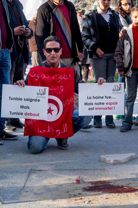 19 mars 2015 : Rassemblement devant les grilles du musée du Bardo au lendemain de l'attaque terroriste qui a fait 19 victimes tunisiennes et étrangères. avec traces de sang au premier plan.
