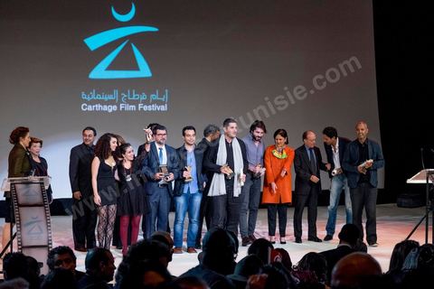 28 novembre 2015 : Photos de famille de l'ensemble des primés. Cérémonie de cloture des JCC au théâtre municipal de Tunis au coeur de la capitale meutrie il y a quelques jours à peine par une attaque suicide terroriste qui a fait 12 morts parmis les policiers de la garde présidentielle. La cérémonie avancée pour cause de couvre feu a été un moment d'hommage à la culture qui a su faire face à la terreur durant cette semaine et l'occasion de primée les artistes et réalisateur du monde arabo-africain. 