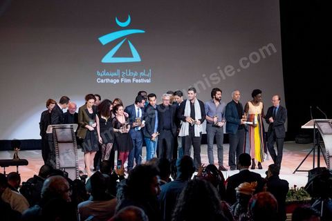 28 novembre 2015 : Photos de famille de l'ensemble des primés. Cérémonie de cloture des JCC au théâtre municipal de Tunis au coeur de la capitale meutrie il y a quelques jours à peine par une attaque suicide terroriste qui a fait 12 morts parmis les policiers de la garde présidentielle. La cérémonie avancée pour cause de couvre feu a été un moment d'hommage à la culture qui a su faire face à la terreur durant cette semaine et l'occasion de primée les artistes et réalisateur du monde arabo-africain. 
