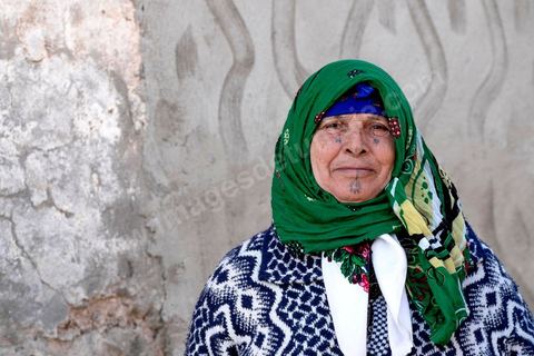 27 janvier 2016 : Portrait de femme traditionnelle tatouée. Quartier populaire et deshérité de Karma sur les hauteurs de Kasserine. Ici la population vit au milieu des poubelles, construisent leurs maison de façon anarchiques jusque dans les oueds. Les familles vivent entassés dans des maisons certes en dure mais dans la plus grande précarité, pas de fenêtres, pas de portes, pas de chauffage et d'eau pour certains. Le seul terrain de jeu des enfants est les poubelles. 