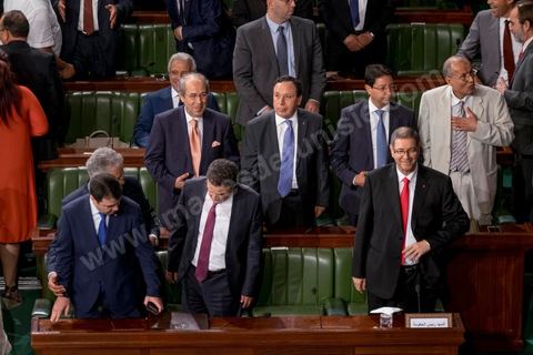30 juillet 2016 : Le banc des ministres du gouvernement de Habib Essid. Après dix-huit mois à la tête du gouvernement tunisien, Habib Essid, technocrate âgé de 67 ans, n’est plus le premier ministre. L’Assemblée des représentants du peuple (ARP), réunie samedi 30 juillet à Tunis, a refusé par 118 voix sur 148 (3 pour et 27 abstentions) de renouveler sa confiance à M. Essid, qui l’avait sollicitée sans trop se faire d’illusions sur l’issue du vote. L’essentiel des députés affiliés aux quatre partis (Nidaa Tounès, Ennahda, Afek Tounès et Union Patriotique Libre) associés à la coalition gouvernementale dirigée par M. Essid ont voté contre la reconduction du premier ministre.Le départ de ce dernier solde le conflit qui l’oppose depuis deux mois au président de la République Béji Caïd Essebsi, âgé de 89 ans. Le 2 juin, le chef de l’Etat avait fragilisé la position de M. Essid en lançant l’idée d’un gouvernement d’« union nationale », une initiative justifiée à ses yeux par la nécessité d’ouvrir une phase plus offensive de l’action gouvernementale. Alors que la Tunisie est confrontée à une économique et sociale très difficile.
